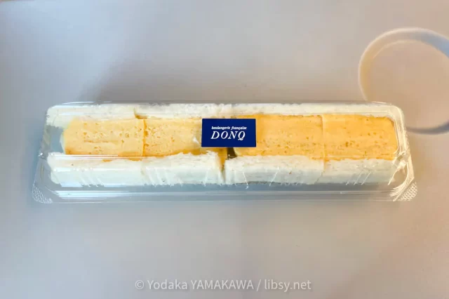 写真：京都駅のDONQで買った玉子サンド。バターを塗った薄切りの食パンで、甘めの厚焼き玉子を包んでいる。