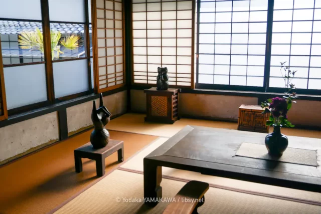 写真：河井寛次郎記念館2階展示室 畳敷の居室に展示されているブロンズ像や竹編みの民具